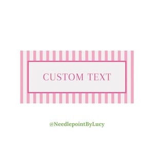 Può includere: Un'etichetta rettangolare con sfondo a righe rosa e bianche. L'etichetta ha un centro bianco con le parole "CUSTOM TEXT" in rosa. L'etichetta è incorniciata con un bordo rosa. Il testo "@NeedlepointByLucy" è in basso.