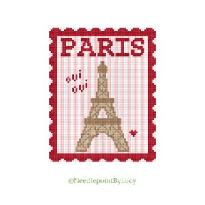 May include: A cross-stitch design featuring the Eiffel Tower in tan, with the word "PARIS" above it. The design includes the words "oui oui" and a small heart, all within a red border.