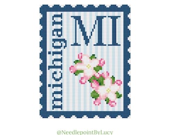 May include: A cross-stitch design of a postage stamp featuring the letters "MI" and the word "Michigan" in navy blue. The stamp includes pink and green floral accents and a blue and white striped background. The design is framed by a navy blue border.