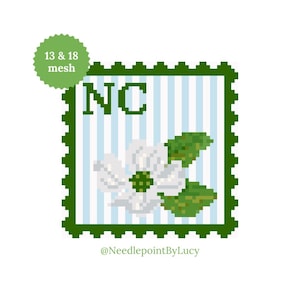 May include: A pixelated design featuring a white dogwood flower, green leaves, and the letters "NC" on a light blue striped background. The design is framed by a green border and includes the text "13 & 18 mesh" and the artist's name.