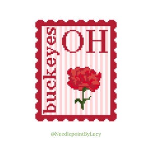 Pode incluir: Um design de ponto cruz que se assemelha a um selo postal. O selo apresenta a palavra "Buckeyes" verticalmente, as letras "OH" e uma flor vermelha. O fundo tem listras verticais rosa e brancas. O selo é emoldurado em vermelho.