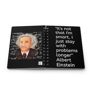 May include: A black and white notebook with a spiral binding. The front cover features a portrait of Albert Einstein with a white background and equations. The back cover features a quote from Albert Einstein: "It's not that I'm smart, I just stay with problems longer".