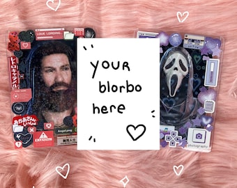 Puede incluir: Dos fundas transparentes para teléfono con elementos decorativos sobre una superficie rosa y esponjosa. Una funda presenta un retrato de hombre y texto japonés, la otra una máscara de Scream. Una tarjeta blanca con el texto "your blorbo here" está en el centro.