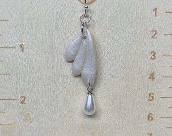 Dangling pearl on a pearlized white polymer clay earrings. Handmade. Hypoallergenic hooks