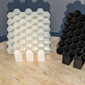 featuring one black ,one white , and one silver posca marker holder.  Showing three different sizes. Front profile