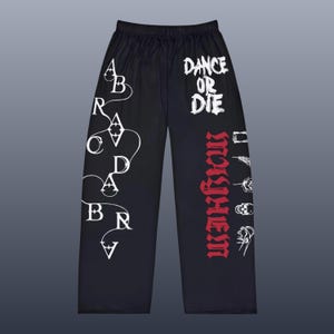 May include: Black wide-leg pants with white and red graphic text. The text includes "DANCE OR DIE" and "WARRIOR". Additional white graphics include a stylized design and various small illustrations.