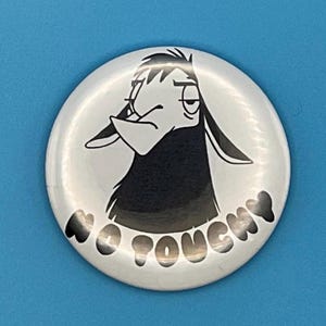 May include: A white button with a black and white illustration of a llama with the text "No Touchy" printed on it.