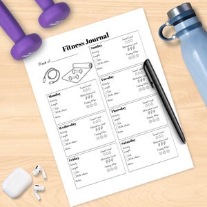 May include: A fitness journal with a black pen, a blue water bottle, and purple dumbbells. The journal is open to a blank page with sections for daily activity, length, and notes. White wireless earbuds are also visible.