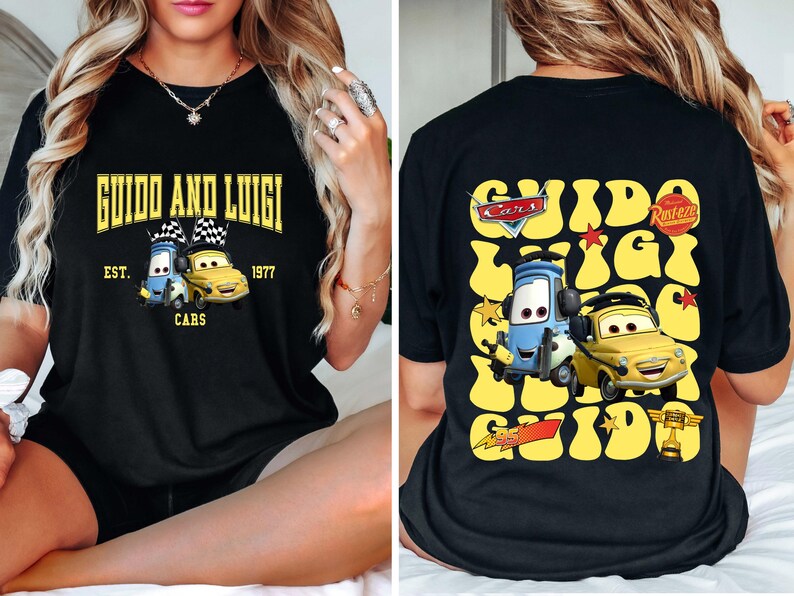 May include: Black t-shirt featuring the text "GUIDO AND LUIGI" above a graphic of two cartoon cars. The front design includes "EST. 1977 CARS". The back of the shirt has a similar design with the text "Cars" and "Rusteze".