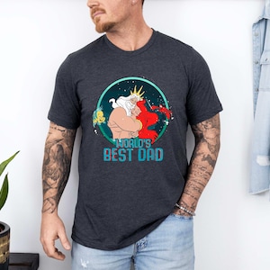 May include: A dark grey t-shirt with a graphic of King Triton and Ariel from The Little Mermaid. The graphic is in a circle with the text "World's Best Dad" below it.