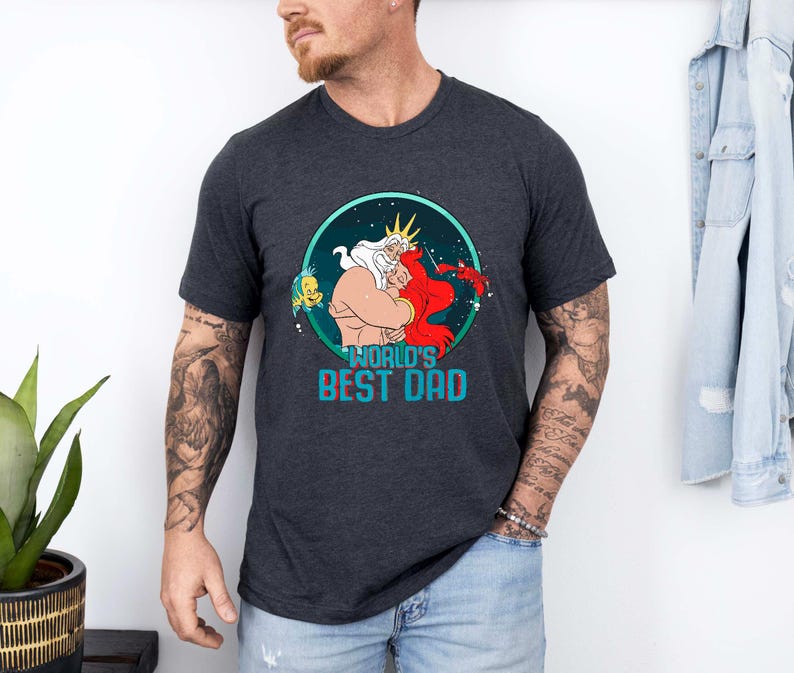 May include: A dark grey t-shirt with a graphic of King Triton and Ariel from The Little Mermaid. The graphic is in a circle with the text "World's Best Dad" below it.