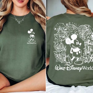 May include: A green sweatshirt with a white graphic of Mickey Mouse on the front and a larger white graphic of Mickey Mouse and the text "Walt Disney World" on the back.