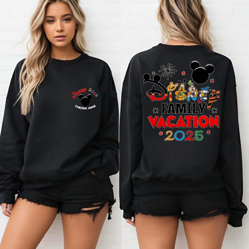 May include: Black sweatshirt with a colourful "Family Vacation 2025" graphic on the back, featuring Mickey Mouse and friends. The front has a smaller "Disney 2025" design with a Mickey head. The design is in red, green, yellow, and black.