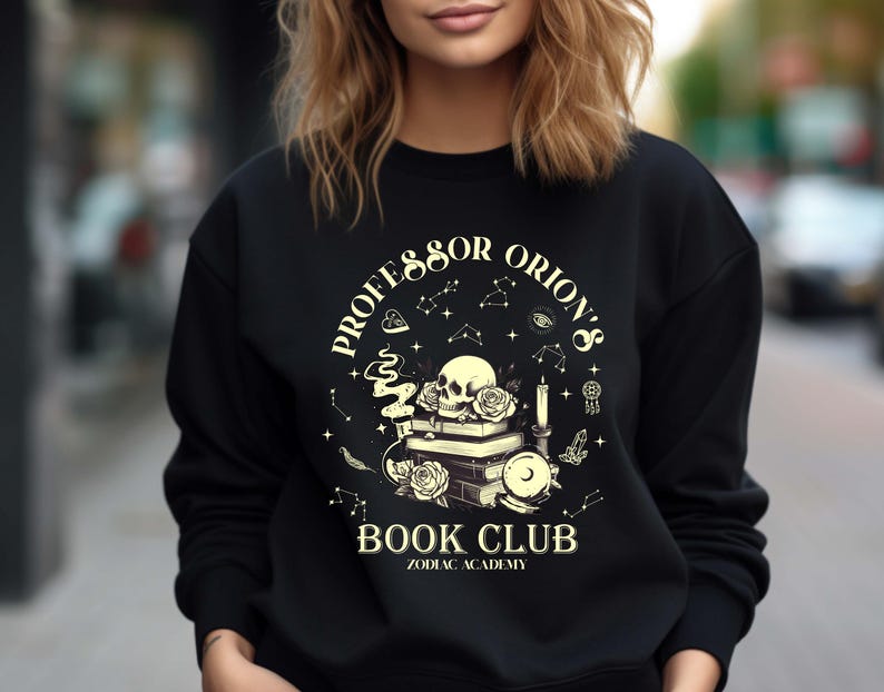 Professor Orion's Book Club Zodiac Academy Sweatshirt is the perfect gift for fantasy readers and book lovers. This cozy crewneck features a stylish design inspired by the popular Zodiac Academy series. Ideal for bookworms who enjoy magical worlds and dark academia vibes. Whether you're reading in a café or relaxing at home, this sweatshirt brings bookish charm and comfort. Great as a birthday or holiday gift for her, especially fans of fantasy romance and dark magic.