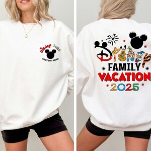 May include: White sweatshirt with a Disney theme. The front features the Disney logo, Mickey Mouse ears, the year 2025, and space for a custom name. The back displays the words "Family Vacation 2025" with Disney character graphics.