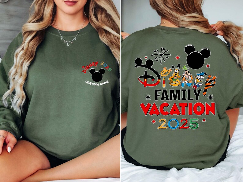 May include: An olive green sweatshirt with Disney graphics. The front has "Disney 2025" and a Mickey Mouse head, with space for a custom name. The back shows "Disney Family Vacation 2025" with Disney characters.