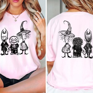Pu&ograve; includere: T-shirt rosa chiaro con un'illustrazione in bianco e nero di tre personaggi dei cartoni animati. La parte anteriore della maglietta mostra i personaggi fianco a fianco, mentre il retro mostra lo stesso disegno. Il design &egrave; in stile stravagante e disegnato a mano.