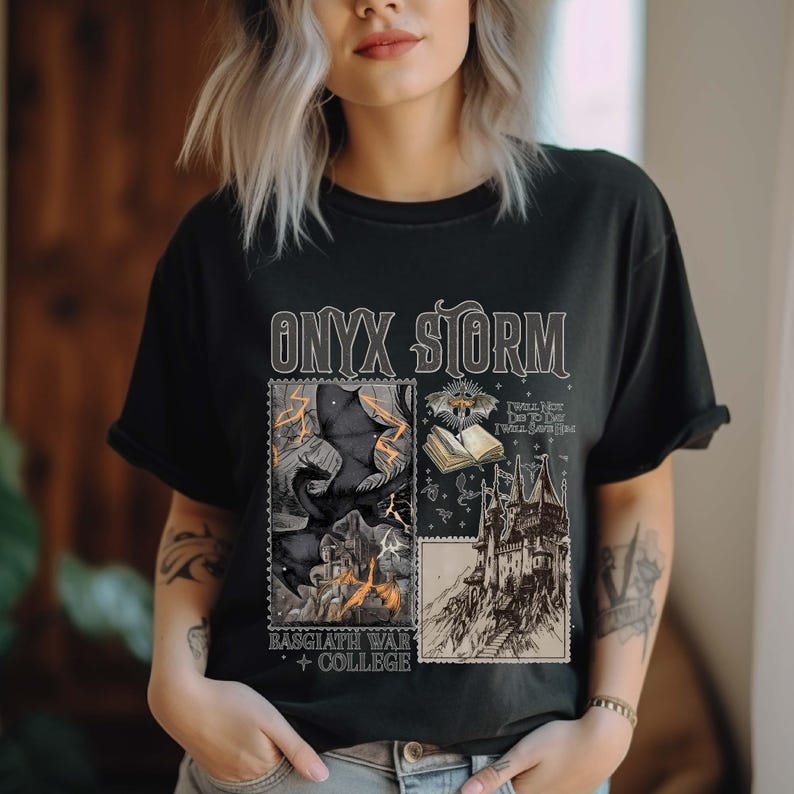 Puede incluir: Camiseta negra con un estampado gr&aacute;fico de un castillo, un murci&eacute;lago, un libro y un cuervo. El texto "ONYX STORM" est&aacute; impreso en blanco en la camiseta. El texto "RAGGATH WAR COLLEGE" est&aacute; impreso en blanco debajo del gr&aacute;fico.