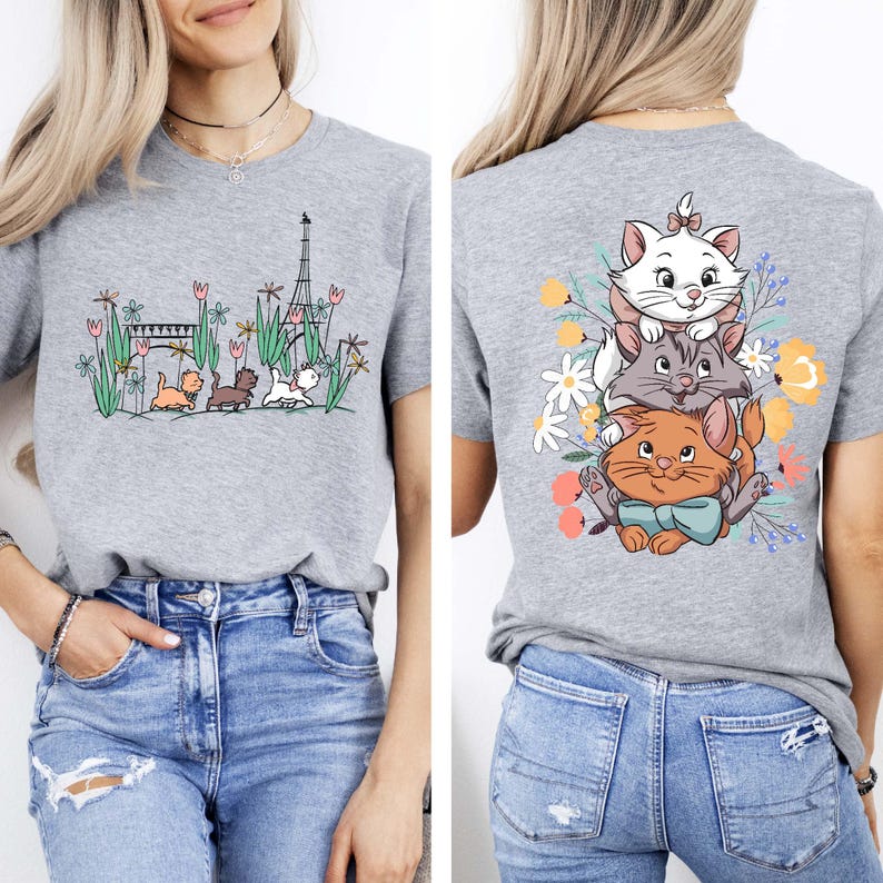 May include: Gray t-shirt with a graphic of three cats stacked on top of each other in front of flowers. The back of the shirt has a graphic of the Eiffel Tower, a bridge, and three cats walking in a line.