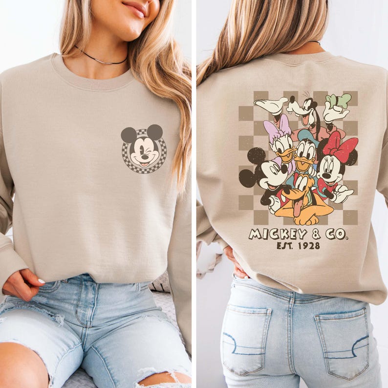 May include: A beige sweatshirt with a Mickey Mouse graphic on the front and a group of Disney characters on the back. The back graphic includes Mickey Mouse, Minnie Mouse, Donald Duck, Goofy, and Pluto. The text "Mickey & Co. Est. 1928" is printed below the graphic.
