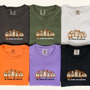 Comfort Colors® shirts with five different-shaped ghosts surrounded by pumpkins and flowers, featuring the phrase “All Bodies Are Bootiful”