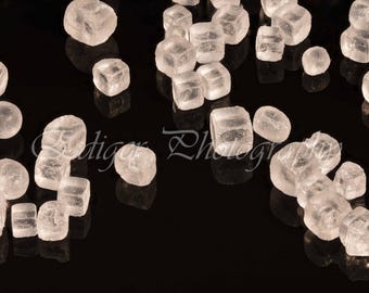 Primer plano macro de cristales de sal sobre una superficie negra reflectante