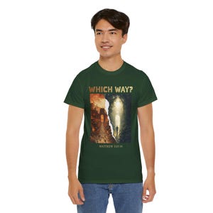 May include: A dark green t-shirt with the words "WHICH WAY?" in gold lettering. The shirt features a split image: one side shows a fiery cityscape, the other a path to light. The text "MATTHEW 7:13-14" is below the image.