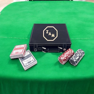 以下が含まれることがあります： 金色のエンブレムが付いた黒いレザーレットのポーカーセット、Players Clubのトランプ2組、緑色のフェルトの表面に2つのポーカーチップのスタック。 ポーカーセットにはキャリングケースが含まれています。
