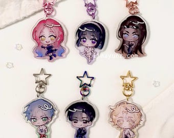 May include: Six colorful anime character keychains with star-shaped charms. Each keychain features a different character with unique hair and clothing styles. The keychains are made of clear acrylic and have a glossy finish.