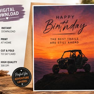 Könnte beinhalten: Eine rechteckige Grußkarte mit einem schwarzen UTV, das bei Sonnenuntergang auf einer Felsklippe steht. Der Text lautet HAPPY Birthday THE BEST TRAILS ARE STILL AHEAD. Der Hintergrund zeigt einen orange-violetten Himmel über Bergen.