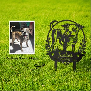 May include: A black metal garden stake featuring a laser-cut silhouette of a dog standing within a circular frame decorated with floral accents. A banner at the bottom displays the name Tucker and the years 2010-2026, accompanied by a reference photo.