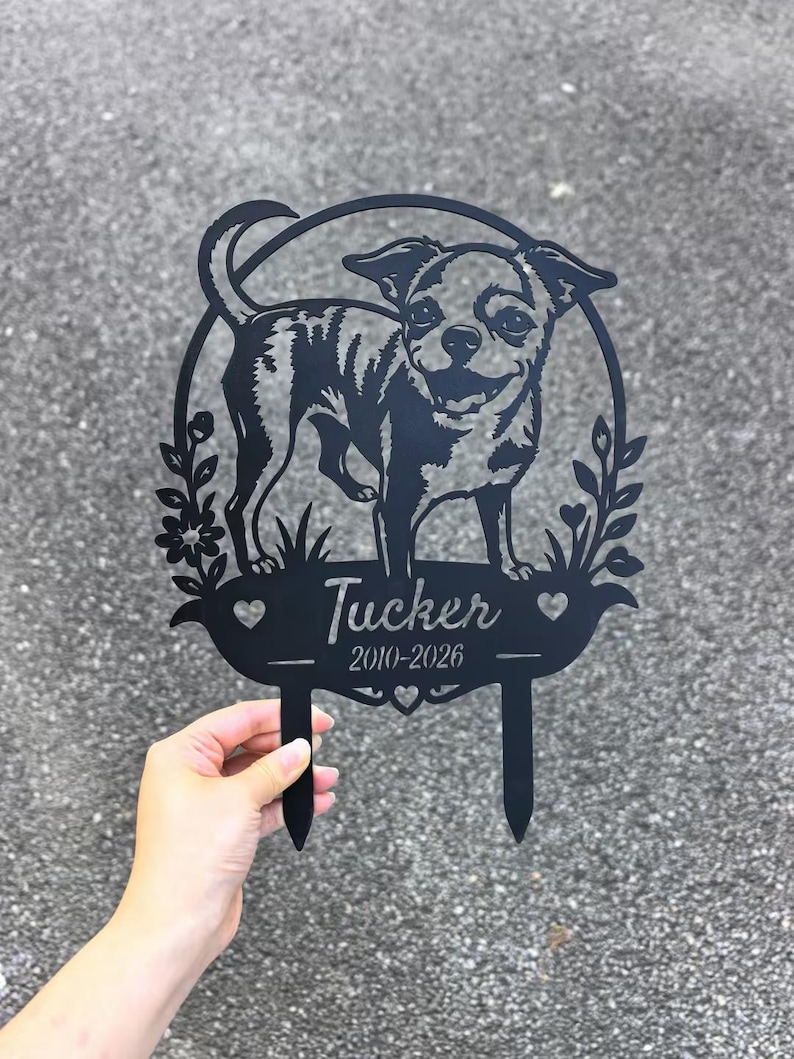 May include: Black metal garden stake featuring a Chihuahua dog design within a circular frame. The stake includes the name "Tucker" and the years "2010-2026". Decorative floral and heart accents are also present.
