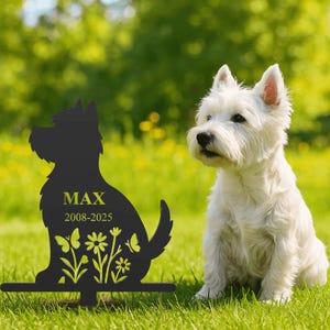 Könnte beinhalten: Ein schwarzer Metall-Gartenstecker in Form eines sitzenden West Highland White Terriers. Die Silhouette zeigt den Namen MAX, die Jahreszahlen 2008-2025 sowie ausgeschnittene Blumen- und Schmetterlingsmotive in leuchtendem Limettengrün.