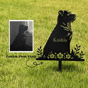 Op de afbeelding: Zwarte metalen tuinpaal met honden silhouet en de naam "Kashis" in gouden letters. De paal heeft een decoratief bloemen- en bladerontwerp aan de basis. Een zwart-wit foto van de hond staat in de linkerbovenhoek. Tekst luidt "Custom From Photo."