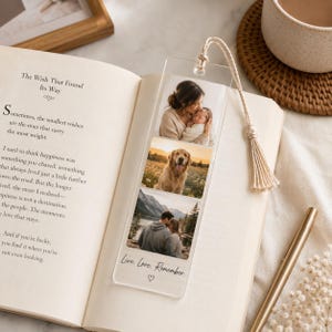 May include: A clear acrylic rectangular bookmark featuring three stacked photographic prints: a person holding a baby, a golden retriever in a field, and a couple standing by a lake. The bookmark has a cream-coloured tassel and the text Live. Love. Remember.