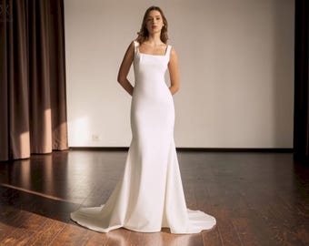 Vestido de novia de sirena con escote cuadrado, vestido de novia minimalista en crepé color marfil, vestido de novia sencillo con espalda baja, botones y cola capilla.