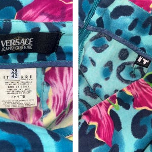 K&ouml;nnte beinhalten: Blaue und rosafarbene gemusterte Hose mit einem schwarzen Etikett mit der Aufschrift "Versace Jeans Couture". Das Etikett enth&auml;lt auch die Gr&ouml;&szlig;e "IT 42" und "28 RRE".