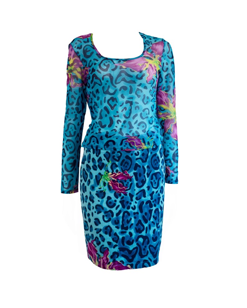 K&ouml;nnte beinhalten: Ein blaues Netzkleid mit Leopardenmuster und Blumendesign. Das Kleid hat lange &Auml;rmel und einen runden Ausschnitt.