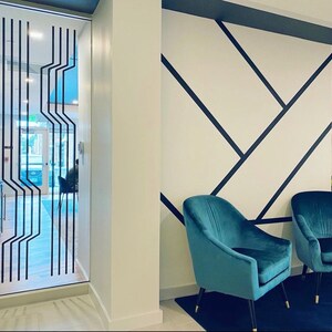 Line wall decals in a geometric pattern by Wall Star Graphics on a glass wall in a minimalist interior.