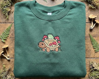 Broderie grenouille chevauchant des tortues, sweat-shirt champignon jardin, sweat à capuche de créature de la forêt, joli col rond amphibien, cadeau esthétique nature