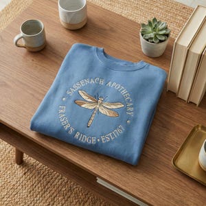 Sudadera bordada de Sassenach Apothecary, Fraser's Ridge, fundada en 1761, cuello redondo con libélula inspirada en Outlander, regalo para amantes de la lectura. imagen 1