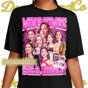 May include: Black t-shirt featuring a graphic of Mina Kimes, an American journalist, with the text "MINA KIMES AMERICAN JOURNALIST" in pink and white. The design includes multiple images of Kimes.