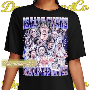 May include: Black t-shirt with a collage of basketball players in blue and white uniforms. The text "Isaiah Evans Man of the Match" is printed on the shirt.