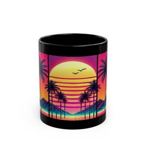 Op de afbeelding: Zwarte keramische mok met een retro zonsondergangontwerp. Het kunstwerk toont palmbomen, een gele zon en vogels, tegen een achtergrond van roze, oranje en paarse tinten. De cilindrische mok is geschikt voor warme of koude dranken.