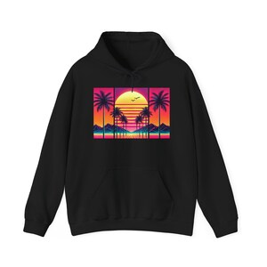 Könnte beinhalten: Schwarzer Hoodie mit einem Retro-Sonnenuntergang-Motiv mit Palmen und einer leuchtend orangen Sonne. Das Motiv ist im Pixel-Stil gehalten.