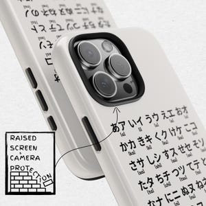 May include: White iPhone case with a raised edge for screen and camera protection. The case has Japanese text printed on the back. The text reads: "a ai u e o ka ki ku ke ko sa shi su se so ta chi tsu te to na ni nu ne no"