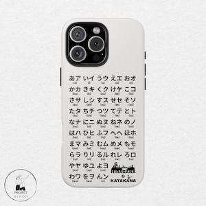 May include: A white phone case with black text showing the Japanese alphabet, Hiragana and Katakana. The text includes the pronunciation of each character in brackets.