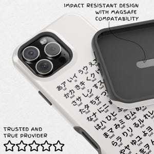 May include: White iPhone case with a black border and a pattern of Japanese characters. The case is compatible with MagSafe and has an impact-resistant design.