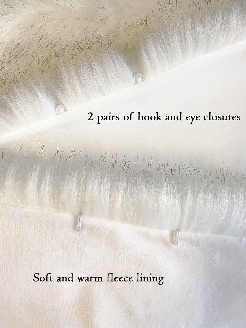May include: Close-up of a white faux fur fabric with two pairs of hook and eye closures. The fabric is lined with a soft and warm fleece lining.