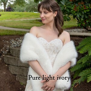 May include: A white faux fur shawl draped over a person wearing a white lace dress. The text "Pure light ivory" is visible in the image.